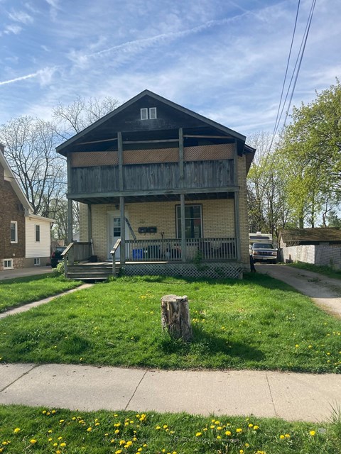 a small house with a porch on the side of a street