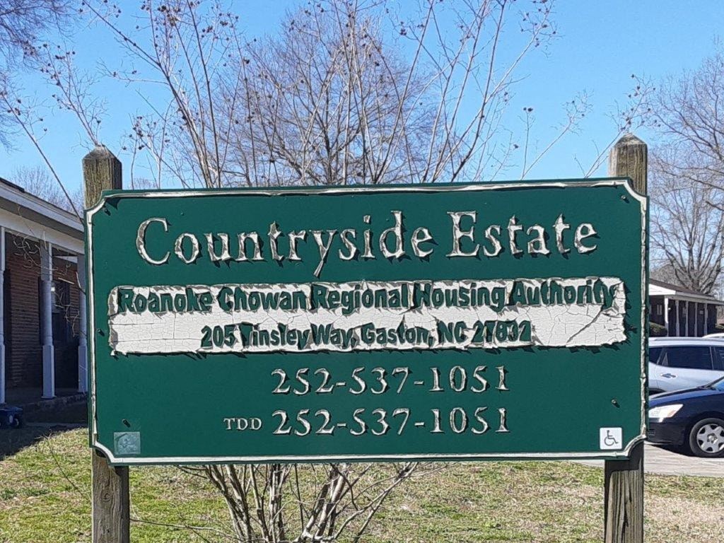 a green sign that says courthouse estate in front of a house