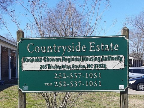 a green sign that says courthouse estate in front of a house