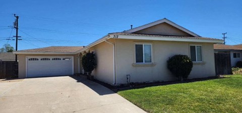 A house with a white garage door and a brown roof.