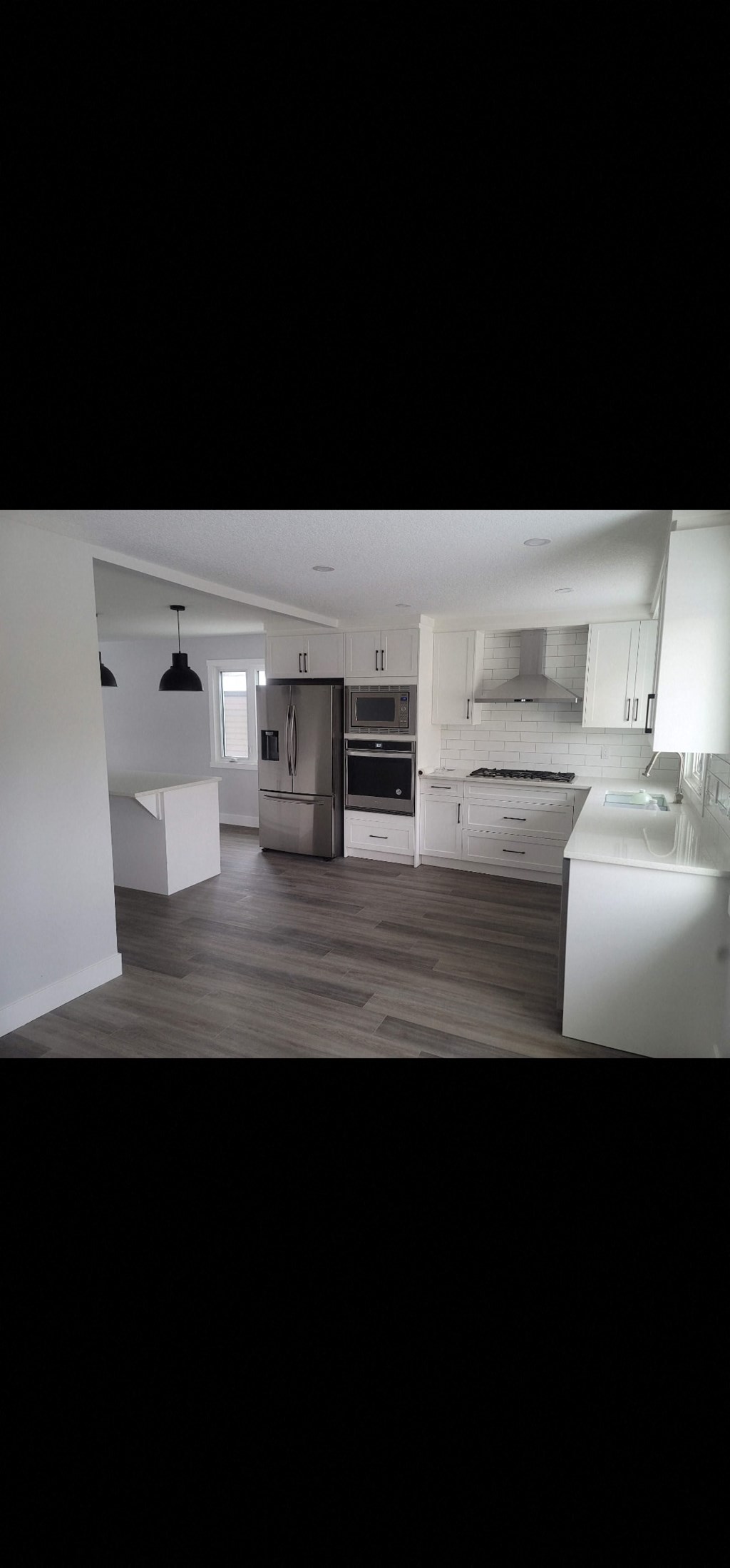 an open kitchen with white cabinets and stainless steel appliances