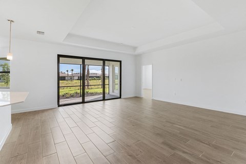 A spacious room with a sliding glass door leading to a garden.