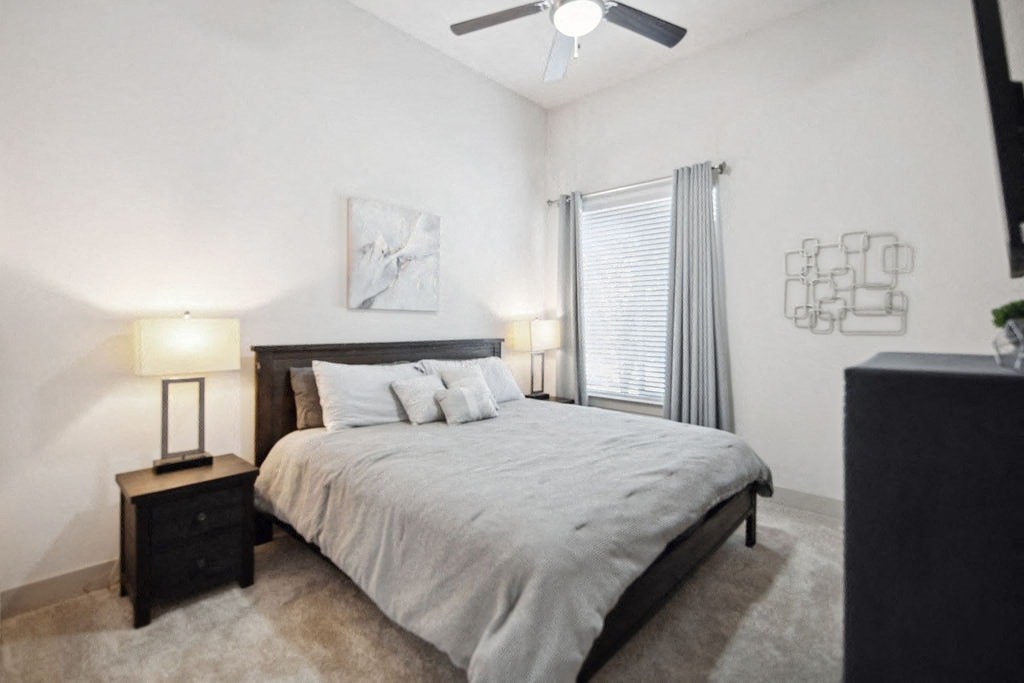 a bedroom with a bed and a ceiling fan