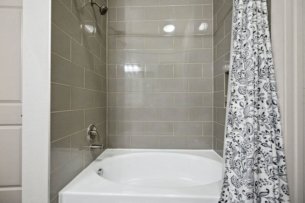 a bathroom with a white tub and a shower curtain