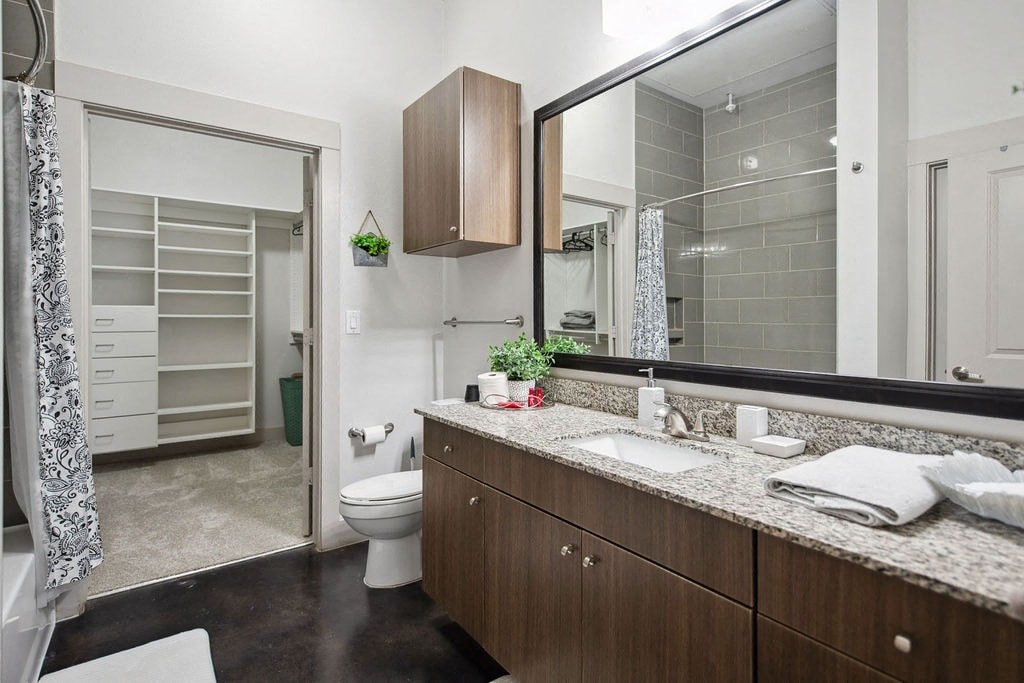a bathroom with a large mirror and a toilet