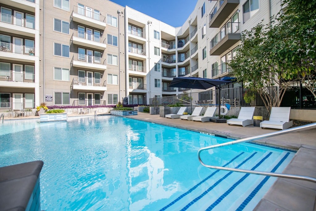 a large swimming pool in front of an apartment building