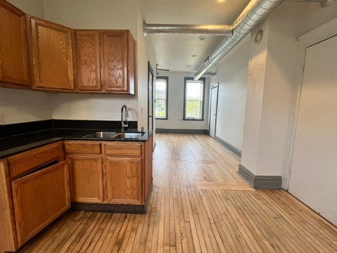 A kitchen with wooden cabinets and a black countertop.