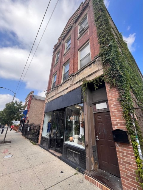 A building with a black awning and a brown door.