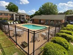 A black fence surrounds a green pool.