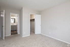 A white room with a carpeted floor and two open doors.
