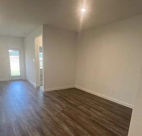 an empty living room with a hard wood floor