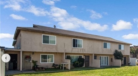 a house with a lawn in front of it and a blue sky