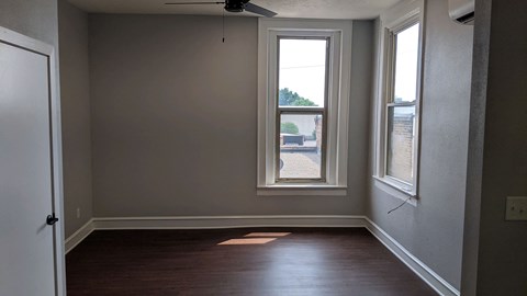 an empty room with a window and wooden floors