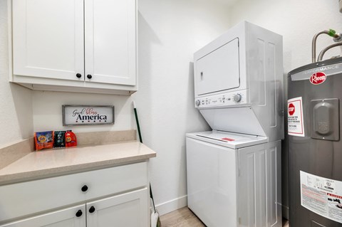 a white kitchen with a refrigerator and a washer and dryer