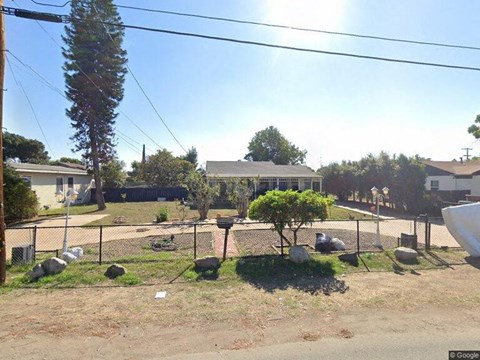 a yard with chickens in a fenced in area