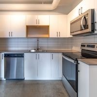 A kitchen with white cabinets and a stainless steel dishwasher.