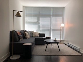 A modern living room with a grey sofa and a black floor lamp.