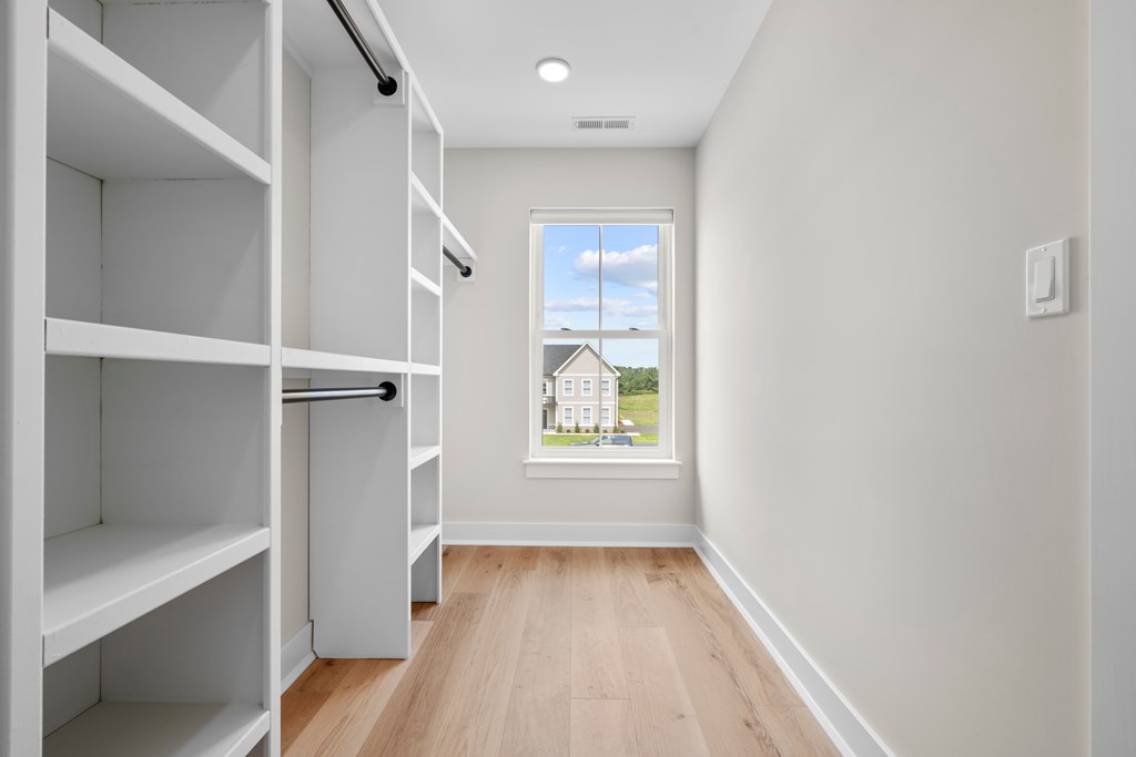 A long hallway with a window and a view of a building outside.