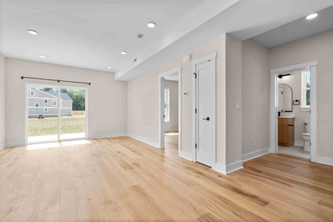 A spacious room with wooden floors and white walls.