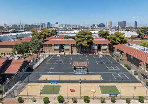 an empty basketball court in a school parking lot