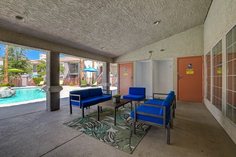 a living room with blue chairs and a table and a pool