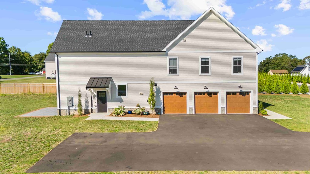 A two-story house with a garage and a driveway.
