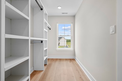 A long hallway with a window and a view of a building outside.