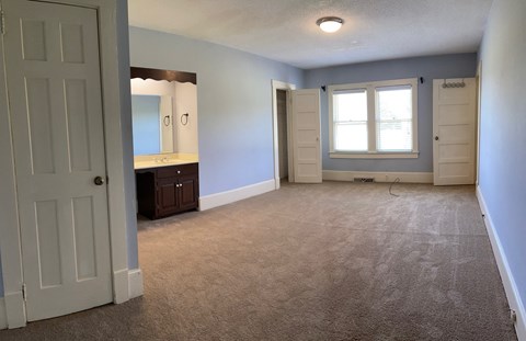 an empty living room with a sink and a window