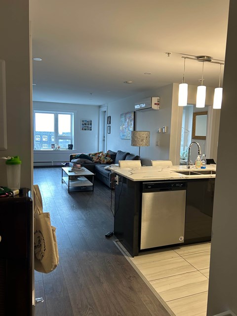 A kitchen with a dining table and chairs is visible from the doorway.