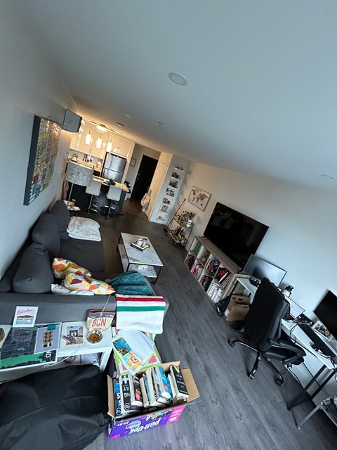 A living room with a couch, chair, and a television.