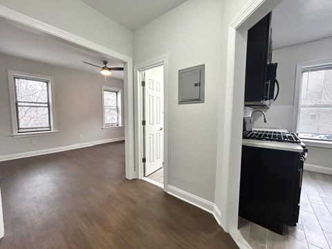 A room with a black fridge and a television on the wall.