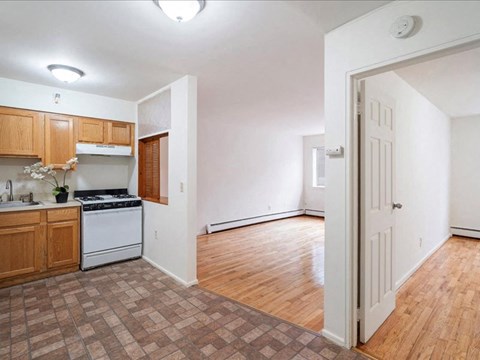 A kitchen with wooden cabinets and a tiled floor.