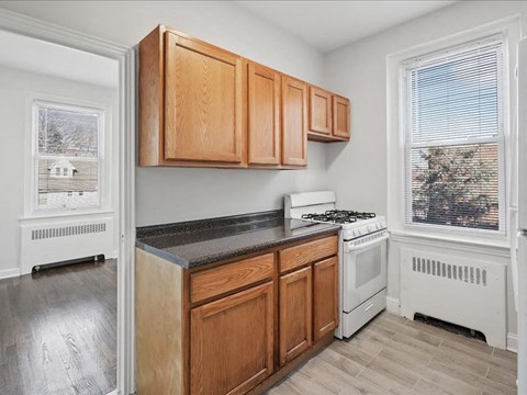 A kitchen with wooden cabinets and a white stove.