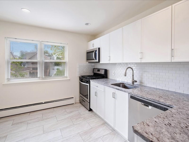A kitchen with a granite countertop and white cabinets.