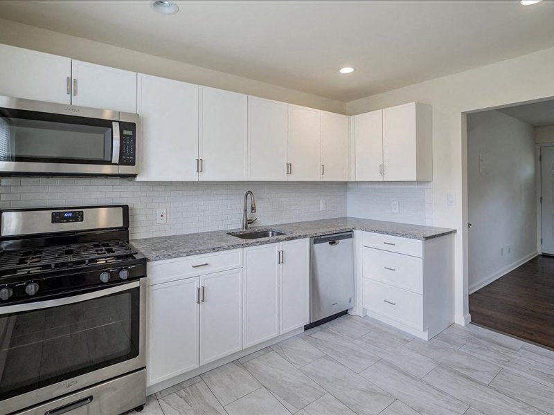 A kitchen with white cabinets and a black stove top oven.