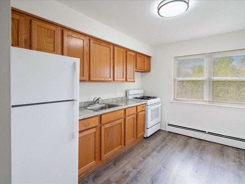 A kitchen with wooden cabinets and white appliances.