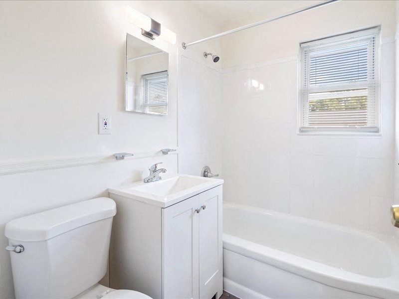 A white bathroom with a toilet, sink, and bathtub.