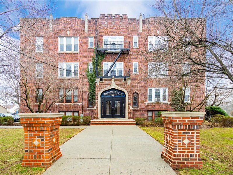 A red brick building with a black door and windows.