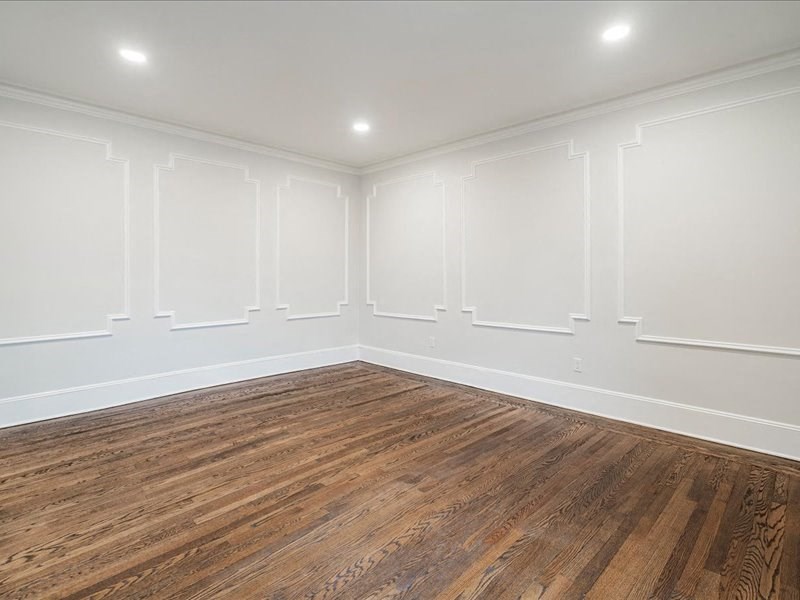 A room with wooden flooring and white walls.