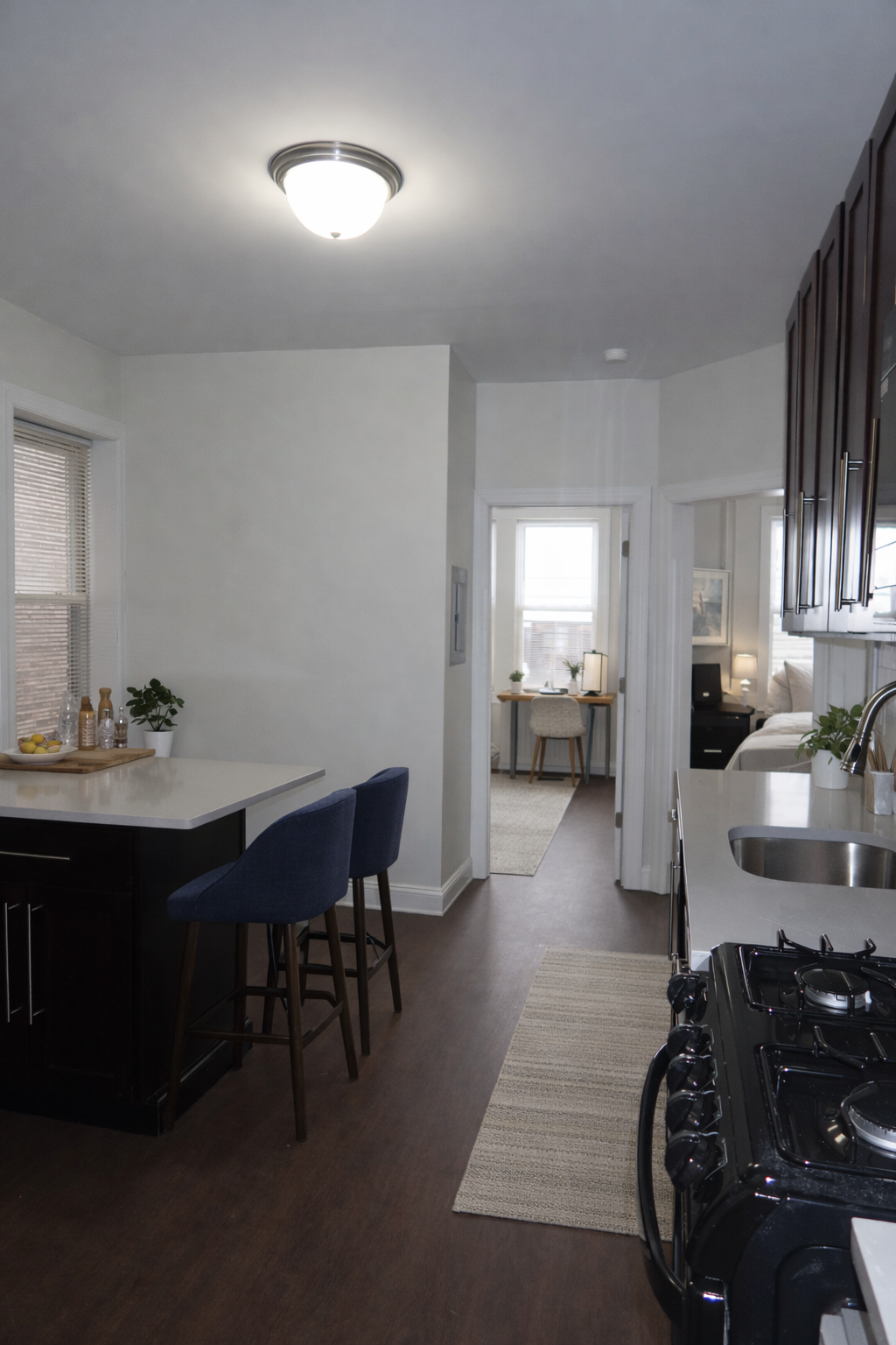 A kitchen with a black stove top oven and a white counter top.