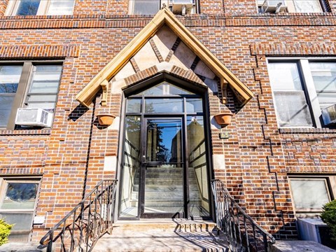 A brick building with a glass door and a metal railing.