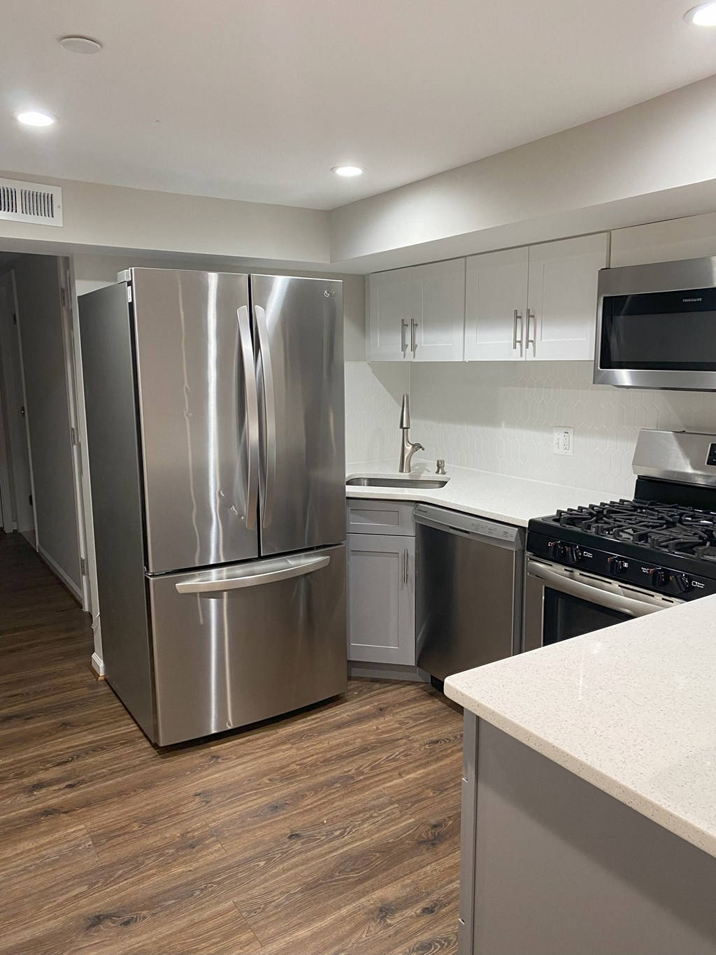 a kitchen with stainless steel appliances and white cabinets