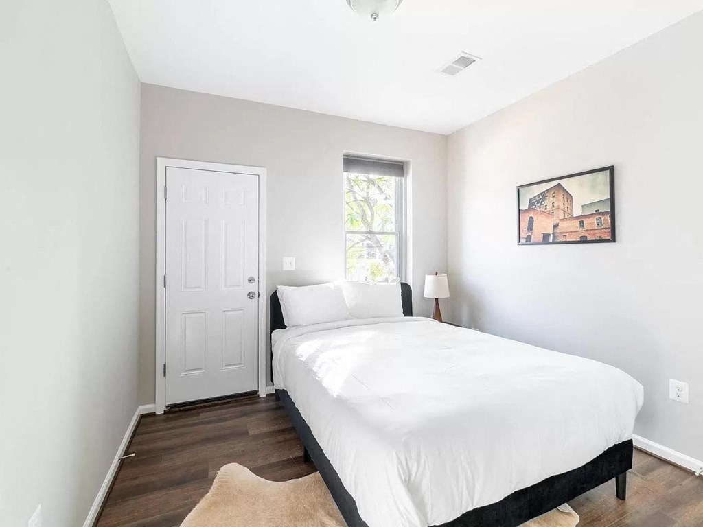 a bedroom with a white bed and a window