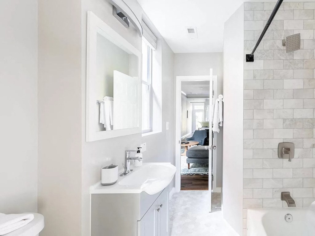a white bathroom with a sink and a mirror