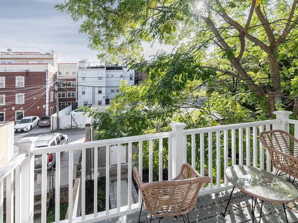 a balcony with a table and chairs and a city street