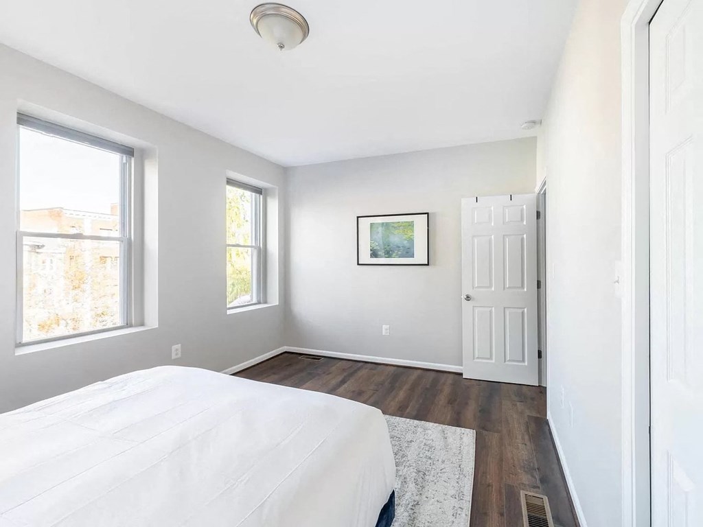 a white bedroom with a white bed and a white door