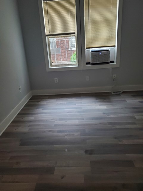 the living room has a hardwood floor and two windows