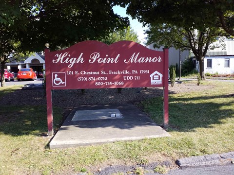 a sign for high point manor in front of a parking lot
