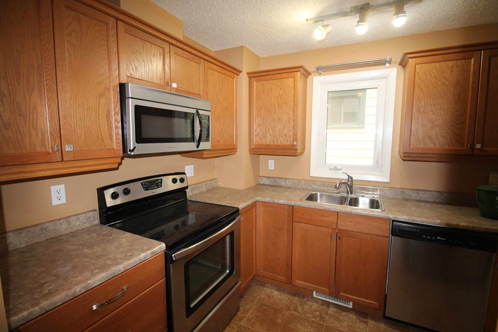 a kitchen with stainless steel appliances and wooden cabinets