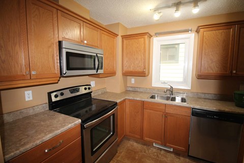 a kitchen with stainless steel appliances and wooden cabinets